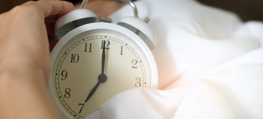 person holiding alarm clock